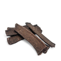 Bio-Rind-Snack-Streifen für Hunde ohne Verpackung, bestehend aus 86% hochwertigem Rindfleisch, Kokosmehl, Chiamehl und Flohsamen. Natürlich konserviert mit Rosmarin und Meersalz.