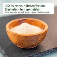 AniForte® Bierhefe Pulver – fein gemahlenes, 100 % natürliches Ergänzungsfuttermittel für Hunde und Katzen in Holzschale präsentiert