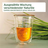 Glas mit einer ausgewählten Mischung verschiedener Naturöle. Das Bild zeigt das Öl in einem transparenten Glas, umgeben von frischen grünen Grashalmen.