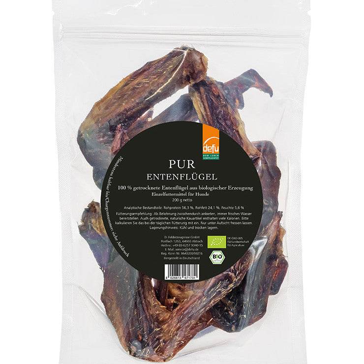 Getrocknete defu Bio-Entenflügel als natürlicher Kausnack für Hunde, auf einem rustikalen Holzbrett angerichtet – ideal zur Zahnpflege und als Kalziumquelle.