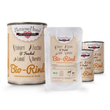 Verschiedene Verpackungen von HerzensHund Bio-Rind, einem Alleinfutter für Hunde. Die Produkte beinhalten Zutaten wie Einkorn, Zucchini, Fenchel, Leinsamen und Karotten. Die Verpackungen sind in Dosen und Beuteln erhältlich.